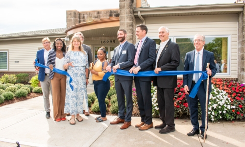 Hawthorne resident Keandra Robinson cuts the ribbon to celebrate the renovation of Hawthorne Place Apartments in Independence, MO.  Joining her for the ceremony are Independence Mayor Rory Rowland, City Manager Zack Walker, Aaron Gornstein, Sevara Davis, Josh Barrett, Jennifer Manulelua with CSL, and Roanoke Construction’s Kevin Buchek and Mike Duffy.